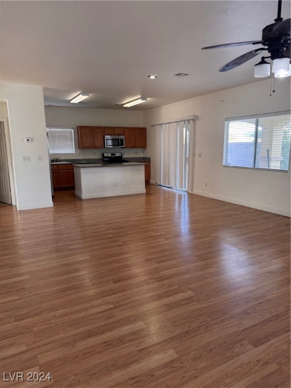 unfurnished living room with ceiling fan and wood-type flooring