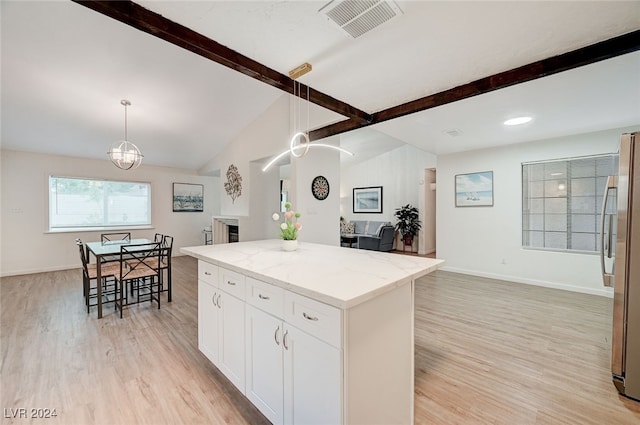 kitchen featuring white cabinets, decorative light fixtures, light hardwood / wood-style floors, and lofted ceiling with beams