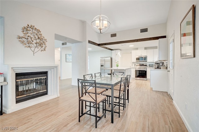 dining area featuring light wood-type flooring and an inviting chandelier