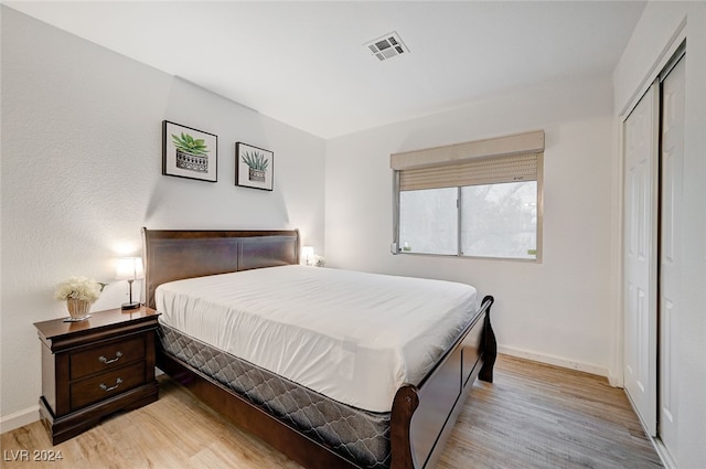 bedroom with light wood-type flooring and a closet