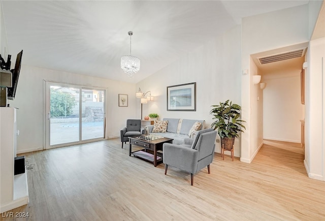 living room featuring an inviting chandelier, vaulted ceiling, and light hardwood / wood-style flooring