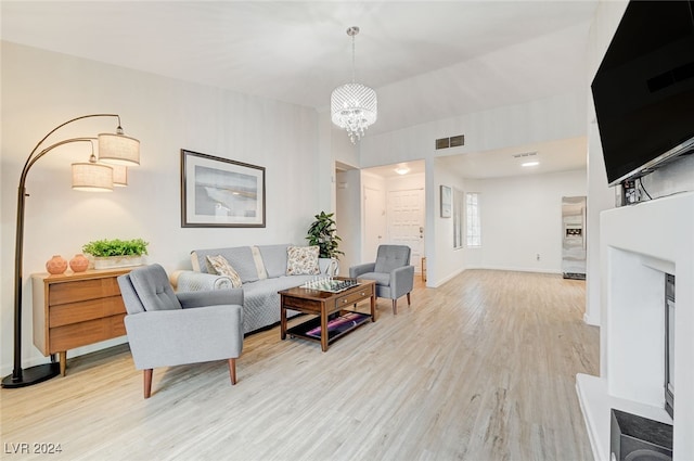 living room featuring an inviting chandelier and light wood-type flooring