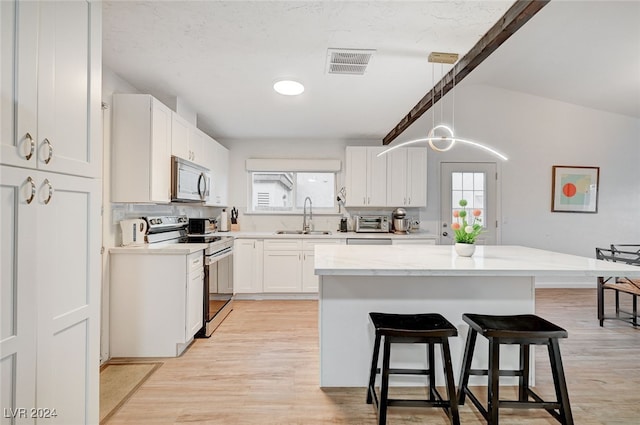 kitchen with light hardwood / wood-style flooring, white cabinetry, sink, electric range oven, and pendant lighting