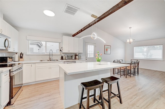 kitchen with vaulted ceiling with beams, a center island, sink, light hardwood / wood-style flooring, and electric stove