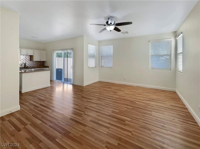 unfurnished living room featuring light hardwood / wood-style floors and ceiling fan