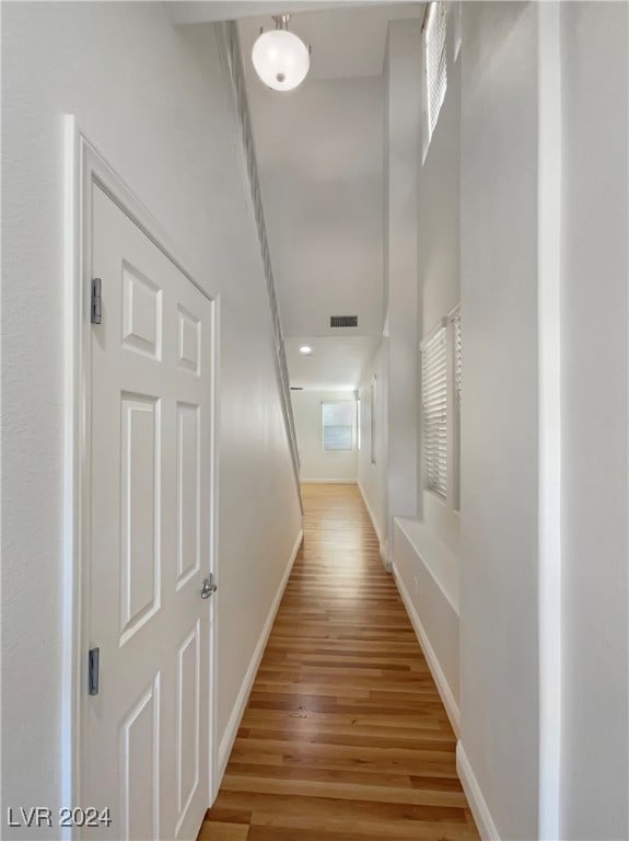 hallway with light hardwood / wood-style floors