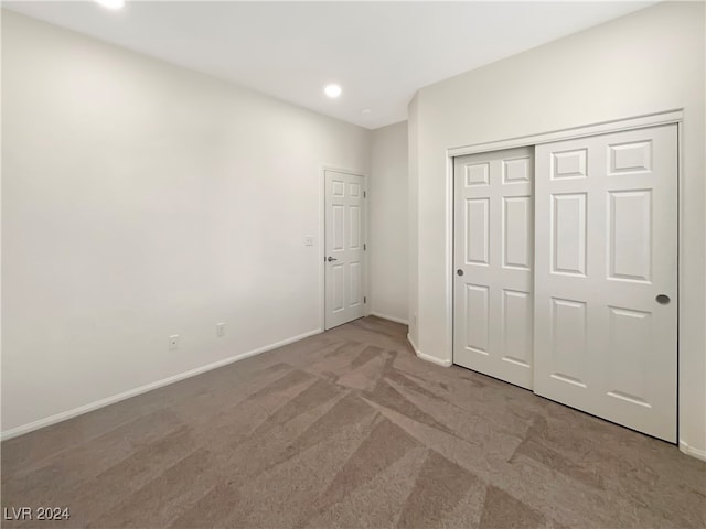 unfurnished bedroom with carpet flooring and a closet