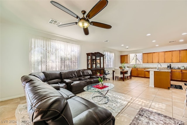 tiled living room featuring ceiling fan and sink