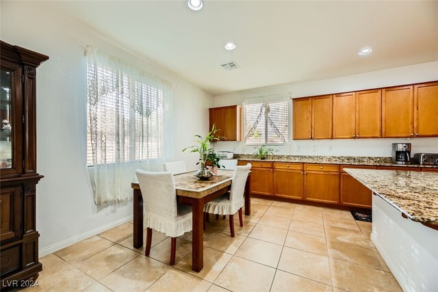 kitchen with light tile patterned floors and light stone counters