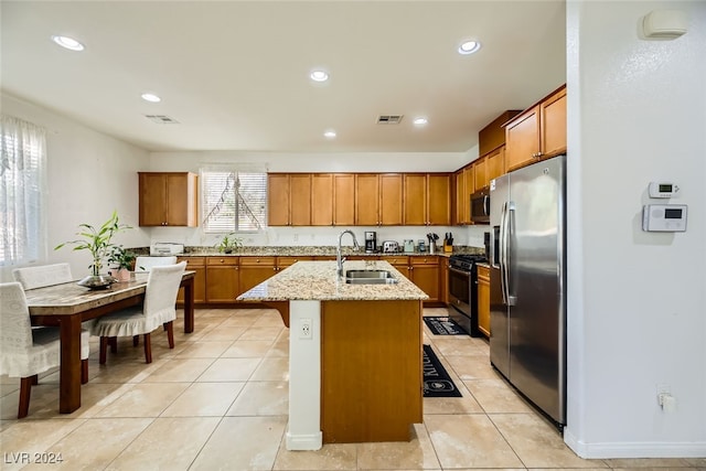 kitchen featuring sink, stainless steel appliances, an island with sink, and light tile patterned floors