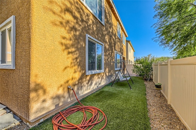 view of side of home with a yard