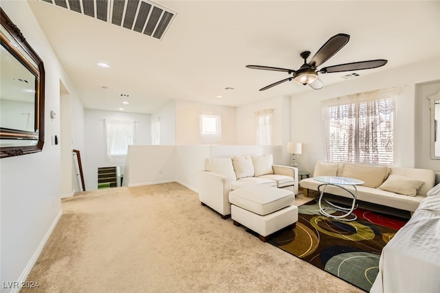 carpeted living room with ceiling fan