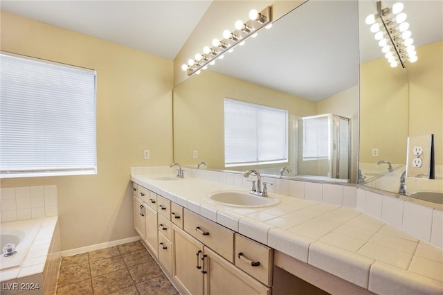 full bathroom with double vanity, a sink, a bath, and a shower stall