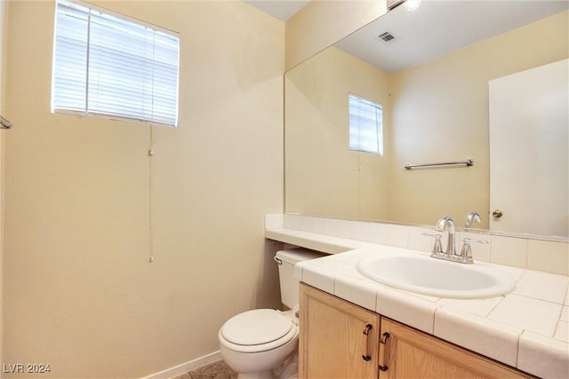 bathroom with toilet, baseboards, visible vents, and vanity