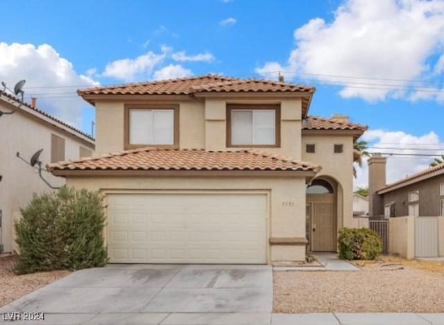 mediterranean / spanish-style house with a garage, driveway, fence, and stucco siding