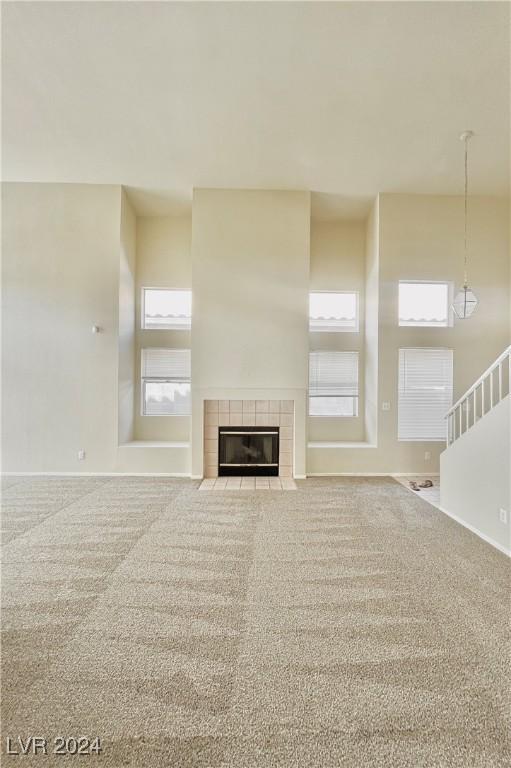 unfurnished living room featuring carpet and a tile fireplace