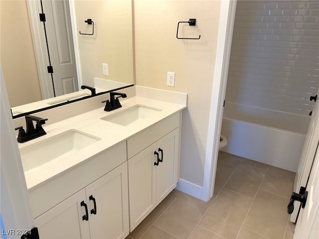 bathroom with toilet, vanity, and tile patterned floors