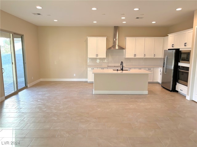 kitchen featuring white cabinetry, wall chimney range hood, sink, and stainless steel appliances