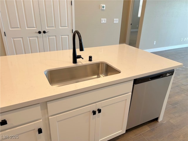 kitchen featuring white cabinets, dishwasher, and sink