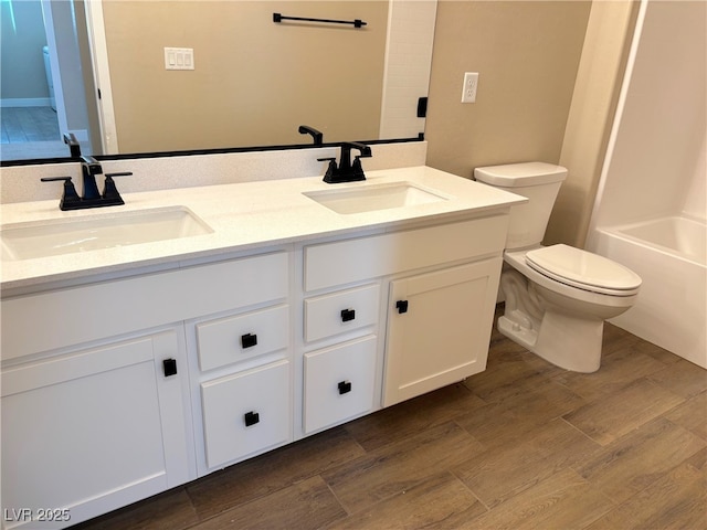 full bathroom featuring vanity, hardwood / wood-style flooring, toilet, and  shower combination