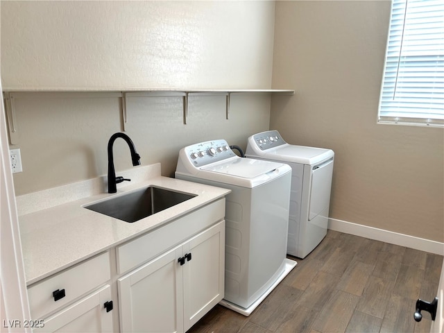 laundry room with cabinets, washing machine and dryer, dark wood-type flooring, and sink