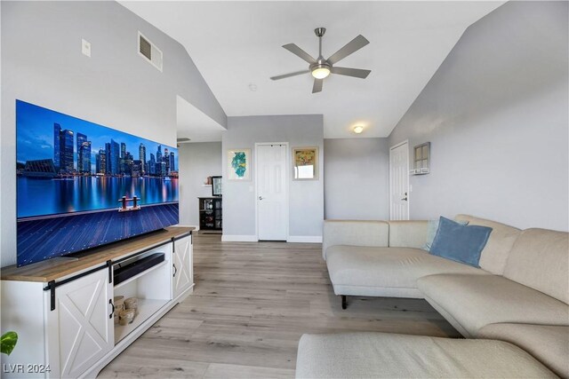 living room with ceiling fan, light wood-type flooring, and high vaulted ceiling