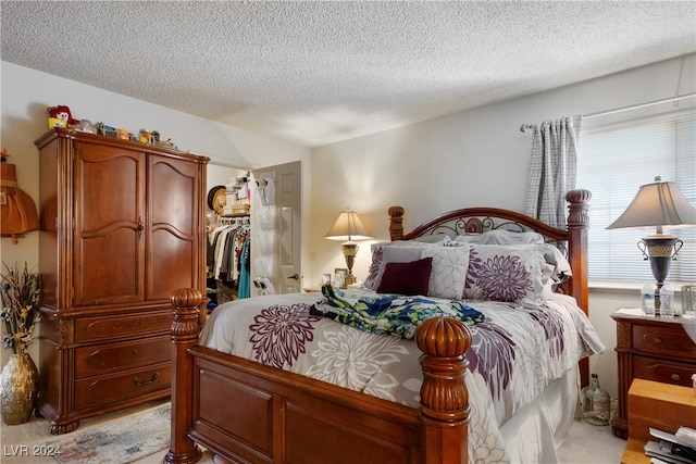 carpeted bedroom with a textured ceiling and a closet