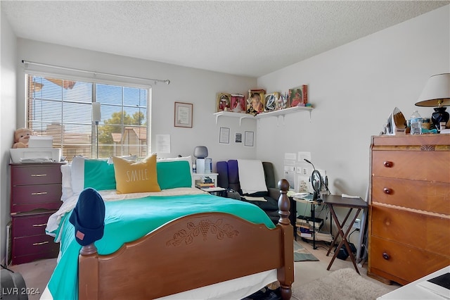 bedroom featuring a textured ceiling and light colored carpet