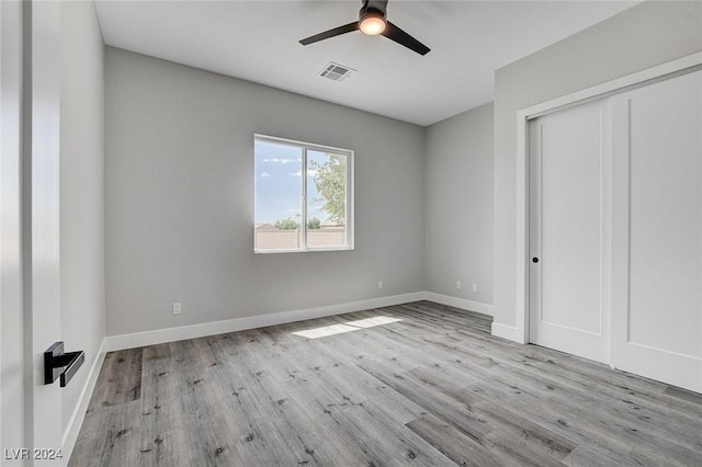 unfurnished bedroom with baseboards, a closet, visible vents, and light wood-style floors