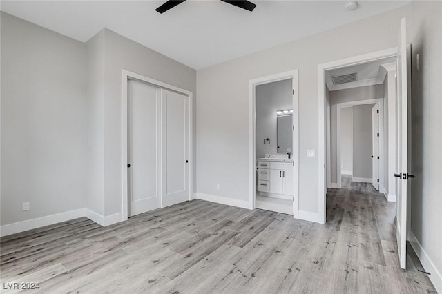 unfurnished bedroom with a closet, visible vents, ensuite bath, light wood-type flooring, and baseboards