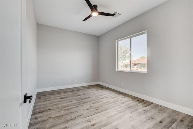 unfurnished room with light wood-style floors, ceiling fan, visible vents, and baseboards