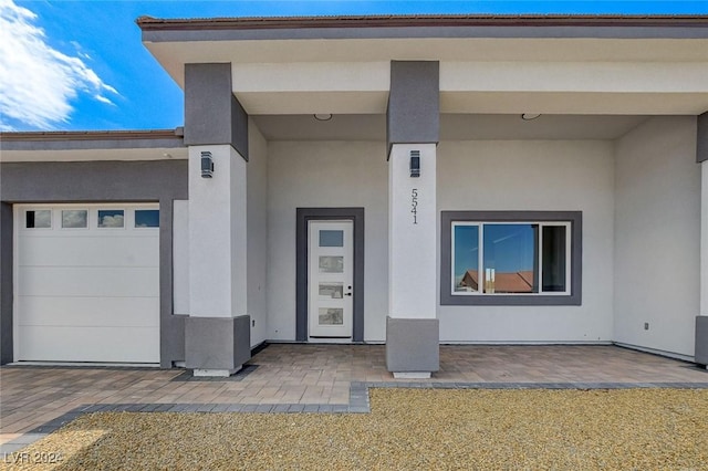 property entrance featuring a patio and stucco siding