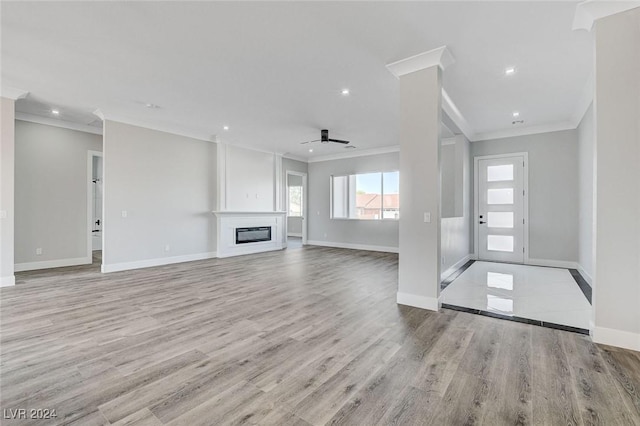 unfurnished living room with recessed lighting, a ceiling fan, baseboards, light wood finished floors, and a glass covered fireplace