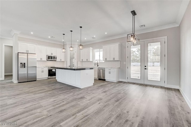 kitchen with appliances with stainless steel finishes, dark countertops, decorative light fixtures, and white cabinetry