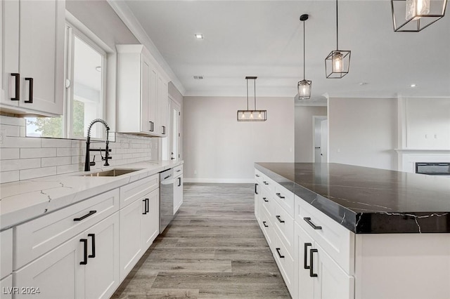 kitchen with a center island, tasteful backsplash, hanging light fixtures, white cabinetry, and a sink