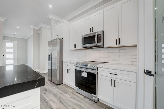 kitchen with light stone countertops, stainless steel appliances, white cabinets, decorative backsplash, and crown molding