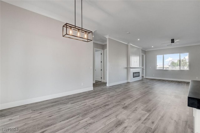 unfurnished living room featuring crown molding, ceiling fan, and light hardwood / wood-style floors