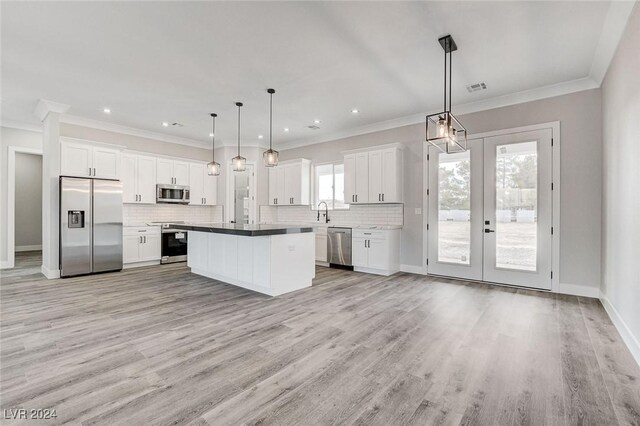 kitchen with pendant lighting, white cabinetry, a kitchen island, and appliances with stainless steel finishes