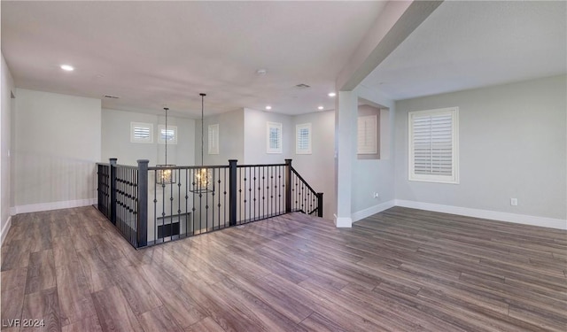 spare room with baseboards, wood finished floors, and recessed lighting