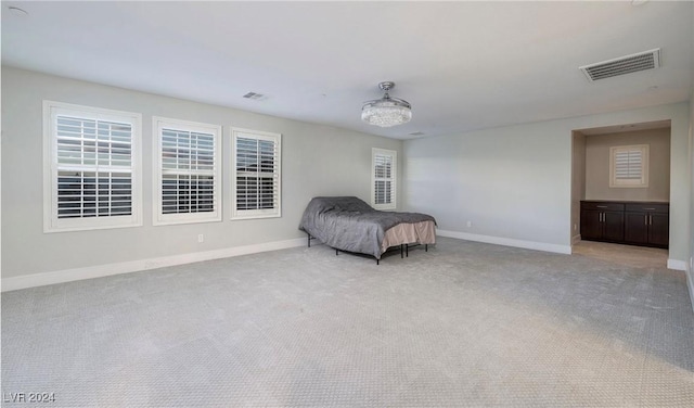 bedroom featuring light carpet, visible vents, and baseboards