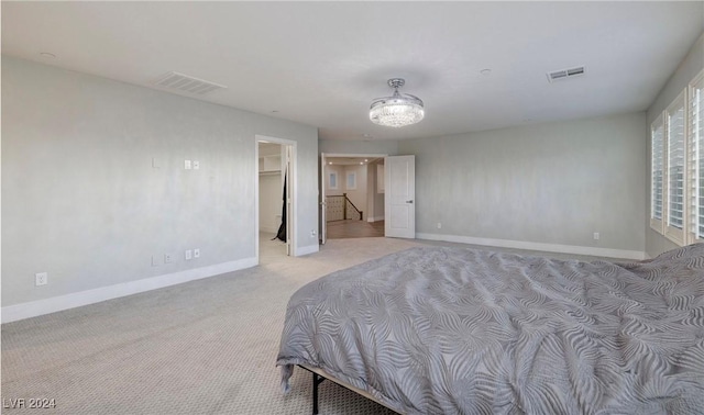 bedroom with visible vents, light carpet, baseboards, and a spacious closet