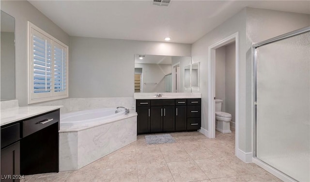 bathroom with a garden tub, toilet, vanity, a shower stall, and tile patterned floors