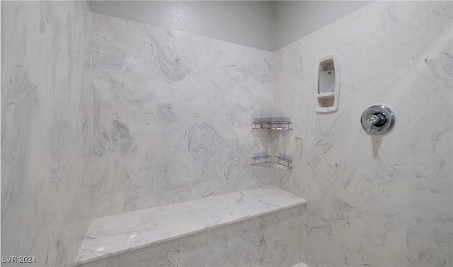 bathroom featuring a marble finish shower