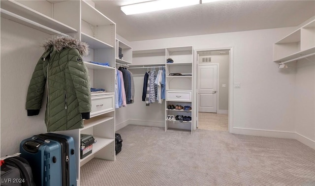 walk in closet with light colored carpet and visible vents