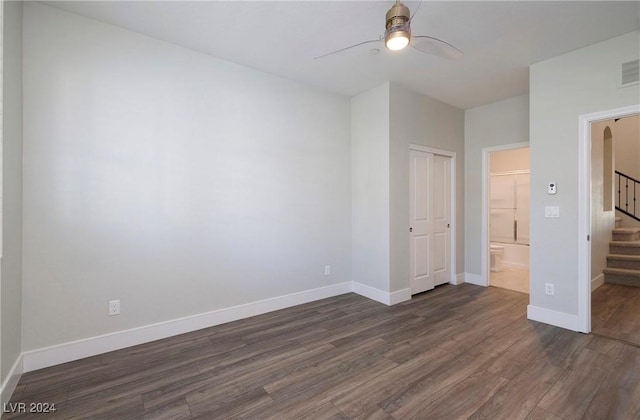 unfurnished bedroom with a closet, dark wood-style flooring, and baseboards