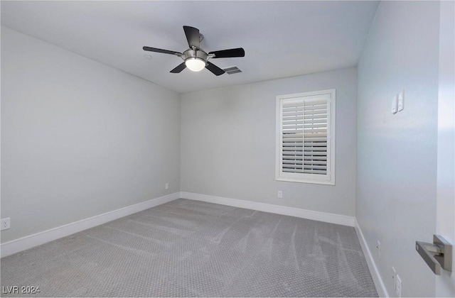 carpeted empty room with visible vents, a ceiling fan, and baseboards