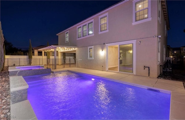 pool at night with a fenced in pool, an in ground hot tub, fence, a patio area, and a pergola