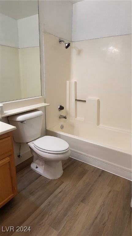 bathroom with toilet, bathtub / shower combination, wood finished floors, and vanity