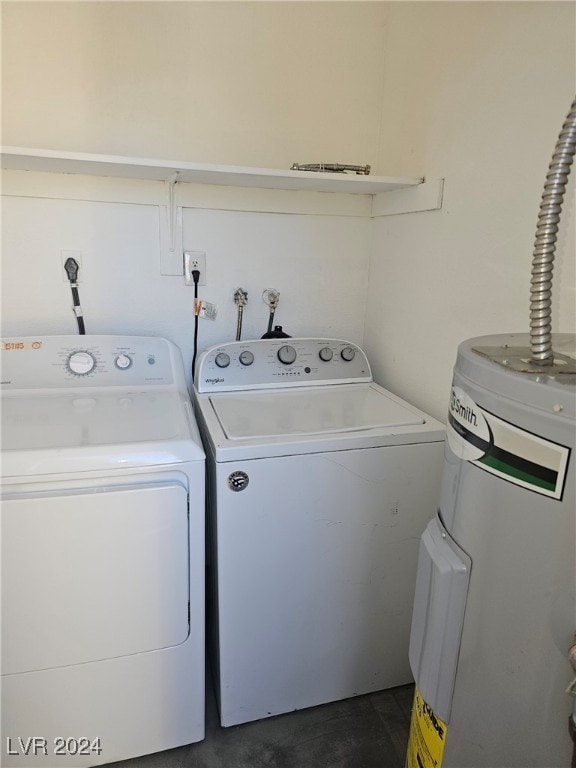 clothes washing area featuring water heater, laundry area, and washing machine and clothes dryer