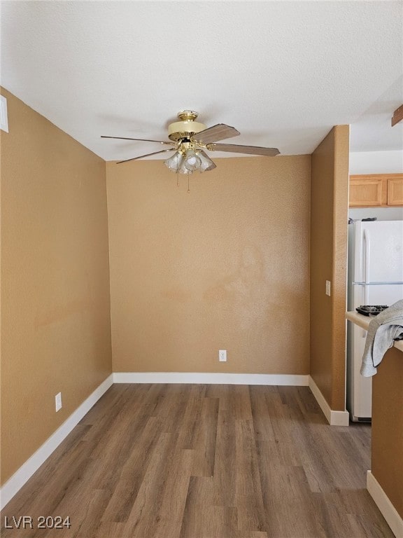 interior space featuring a ceiling fan, dark wood finished floors, and baseboards